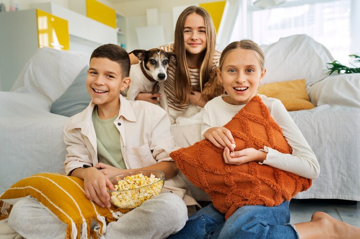 Foto grátis primos passando tempo juntos em casa e assistindo tv com pipoca