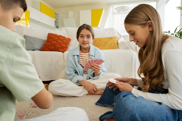 Foto grátis primos passando tempo juntos em casa e jogando cartas