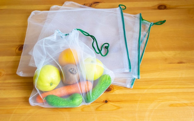 Princípio de desperdício zero. saco têxtil reciclado sem plástico para frutas ou legumes em uma superfície de madeira.