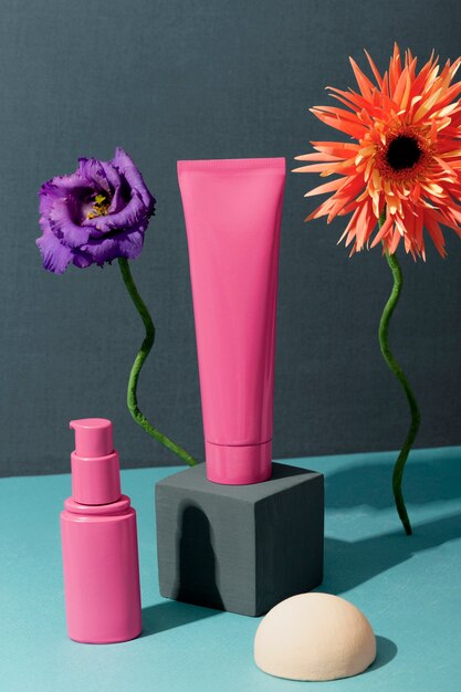 Produtos cosméticos cor de rosa e flores