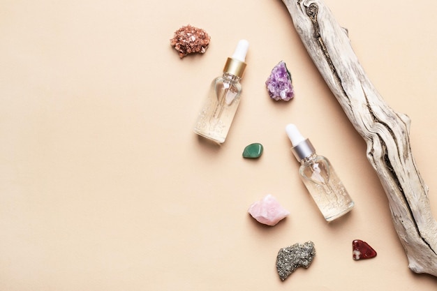 Produtos cosméticos em gel líquido, pedras semipreciosas naturais e pedaços de árvores antigas. conceito de cuidado de pele de beleza.