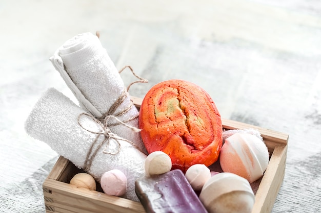 Produtos de beleza em caixa de madeira. sabonete, toalha com bomba de banho laranja. spa ou conceito de higiene pessoal