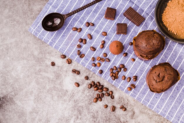 Produtos de chocolate e ingredientes no guardanapo sobre o pano de fundo concreto