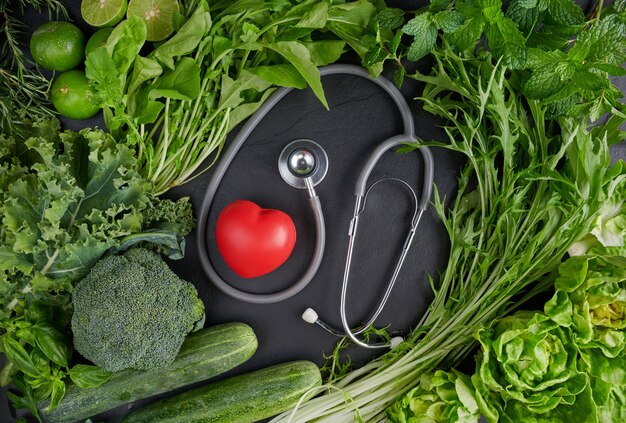 Produtos vegetarianos orgânicos verdes com coração perto do estetoscópio