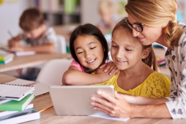 Professor ajudando alunos com tablet digital