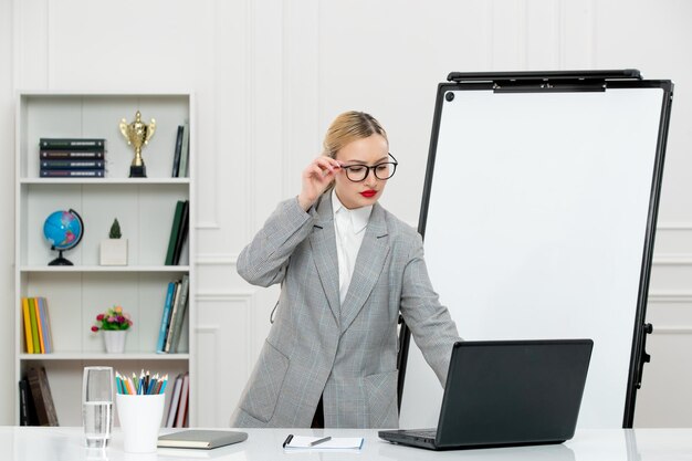 Professor bonito instrutor de terno na sala de aula com computador e quadro branco olhando para a tela