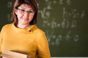 Foto grátis professor com pilha de livros na sala