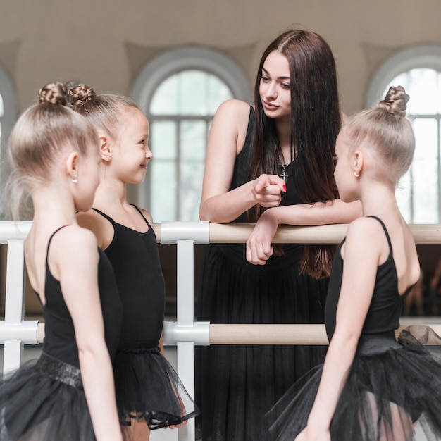 Professor dando instruções para suas meninas de balé no estúdio de dança