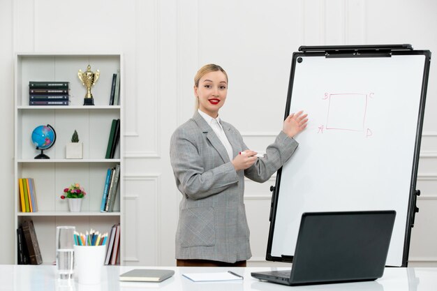 Professor jovem instrutor bonitinho de terno na sala de aula com laptop e quadro branco desenhando quadrado
