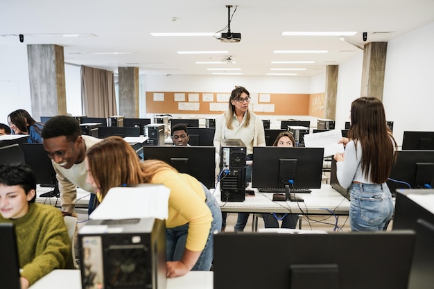 Professor maduro trabalhando com alunos dentro da sala de informática na escola - foco no rosto da mulher