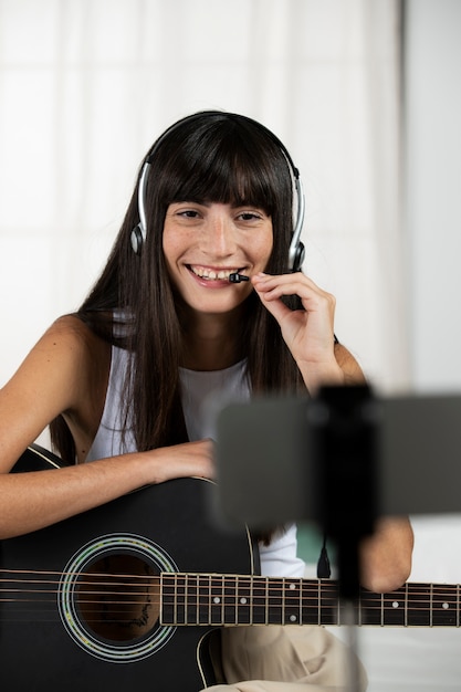 Professor sorridente de tiro médio com guitarra