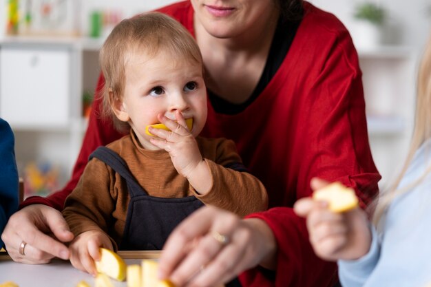 Professor sorridente segurando criança comendo