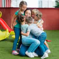 Foto grátis professora abraçando seus alunos