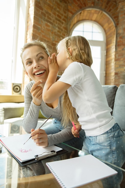 Professora caucasiana feminina e menina, ou mãe e filha.