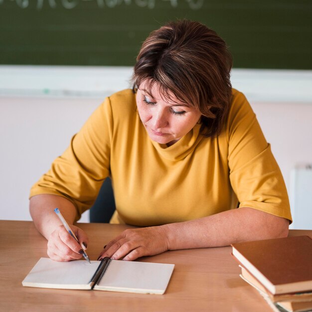 Professora escrevendo na mesa