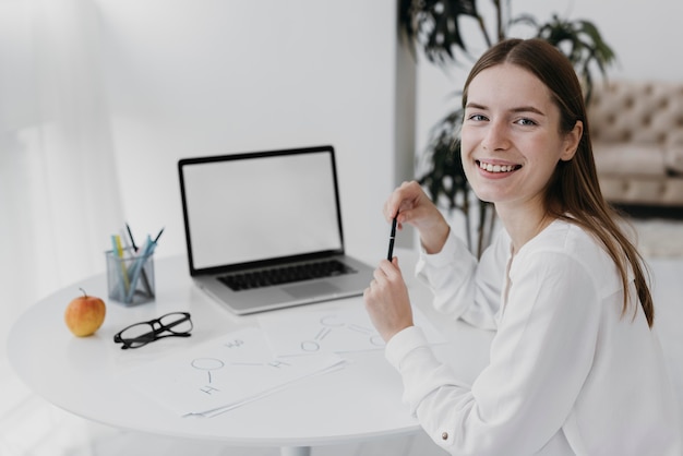 Professora sorridente em frente ao laptop