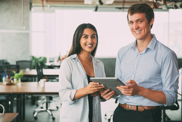 Profissionais alegres que usam a tecnologia no trabalho