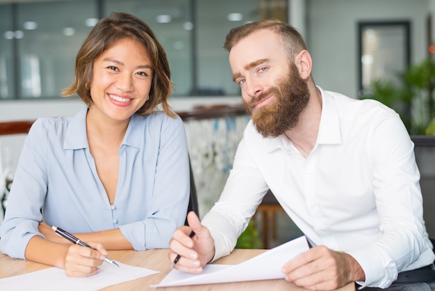 Profissionais de sucesso felizes estudando relatórios