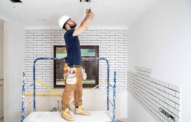 Profissional de macacão com ferramentas no fundo do local de reparo. conceito de renovação em casa.