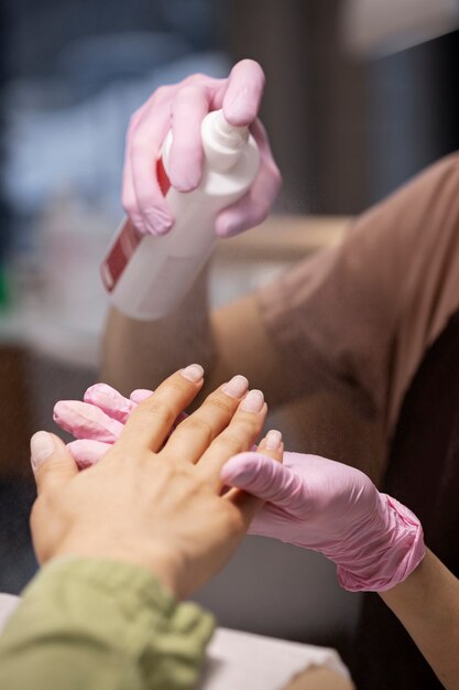 Profissional de nail art trabalhando em unhas de clientes