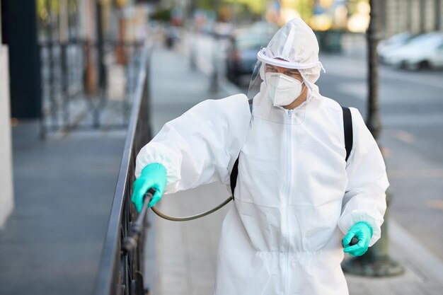 Profissional de saúde em traje de proteção desinfetando a cidade durante a epidemia de coronavírus