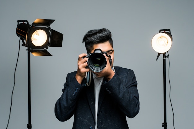 Profissional jovem fotógrafo indiano tirando fotos em estúdio com leight