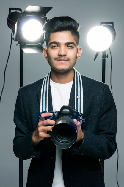 Profissional jovem fotógrafo indiano tirando fotos em estúdio com leight