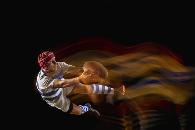 Foto grátis pronto para voar pela vitória. um homem caucasiano jogando rúgbi no estádio sob uma luz mista