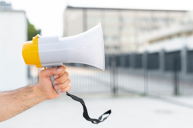 Protestador de close-up segurando o megafone