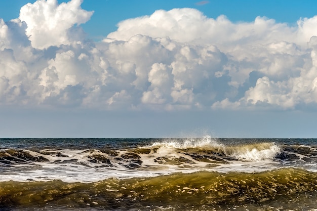 Próximas nuvens de tempestade e ondas quebrando na praia de Kijkduin em Haia