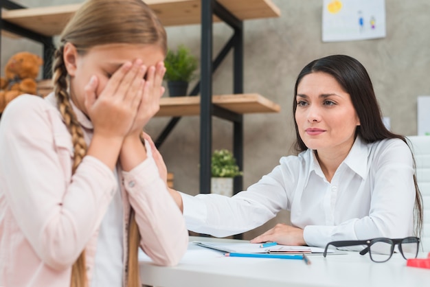 Psicólogo feminino, apoiando a menina triste paciente durante a discussão do problema