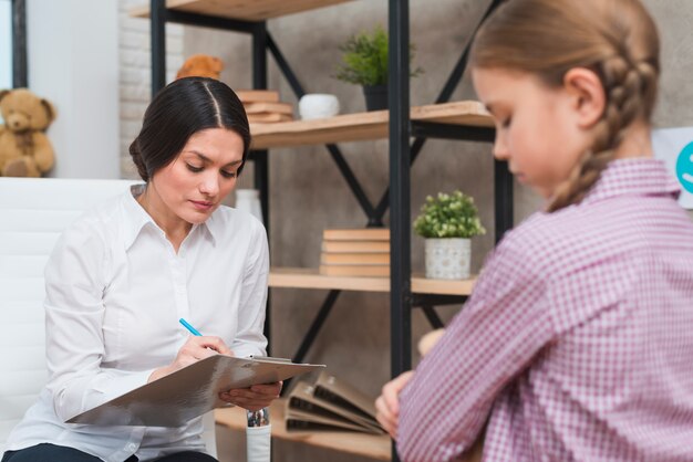 Psicólogo feminino tomando notas na área de transferência na sessão de terapia