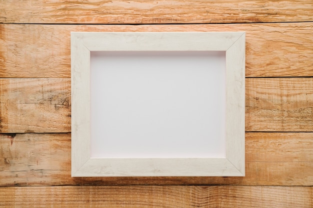 Quadro branco minimalista leigo plano com fundo de madeira