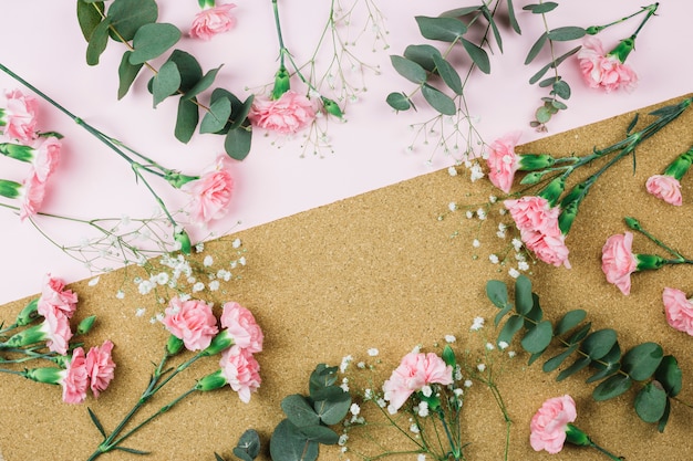 Foto grátis quadro circular feito com gypsophila e rosa flores de cravo em pano de fundo duplo-de-rosa e papelão