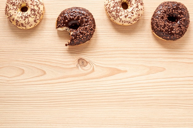 Quadro de comida vista superior com donuts e fundo de madeira