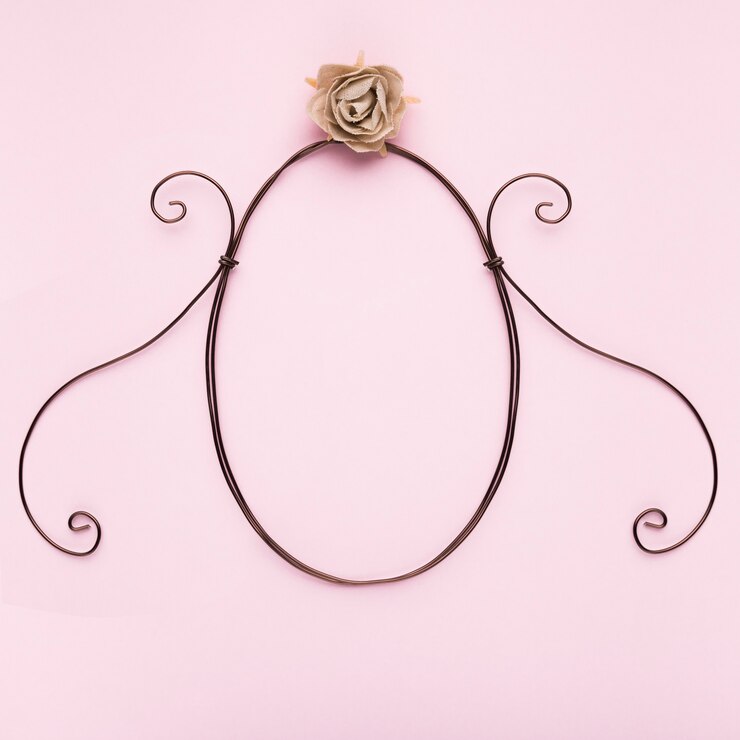 Foto grátis quadro de forma oval com artificial rosa no pano de fundo rosa