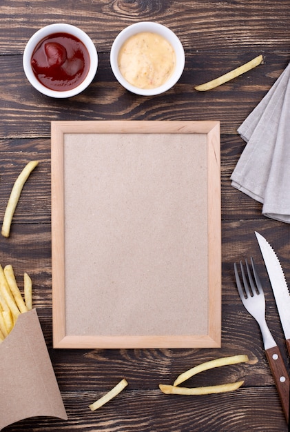 Foto grátis quadro de vista superior ao lado de hambúrguer e batatas fritas