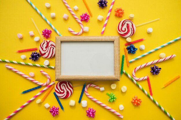 Quadro em branco cercado por doces do aniversário