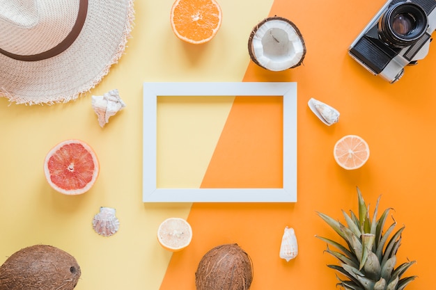 Quadro em branco com acessórios de viagem, frutas e conchas