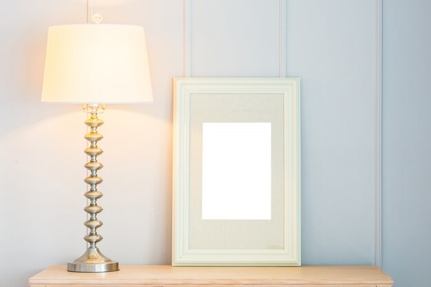 Quadro em branco com decoração de luz da lâmpada na mesa