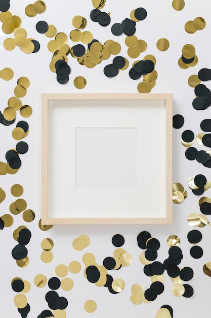 Quadro em branco com lantejoulas na mesa