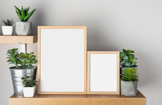 Foto grátis quadro em branco na prateleira ao lado de vasos de flores