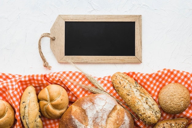 Foto grátis quadro em forma de tag perto de pão e pano