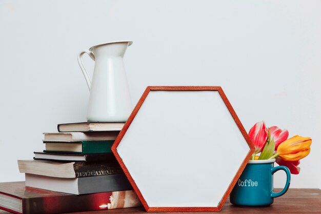 Quadro hexagonal perto de flores e livros