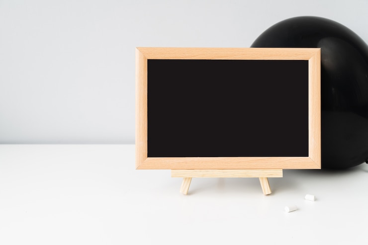 Foto grátis quadro-negro com giz na frente do balão preto