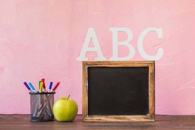 Quadro negro com letras do alfabeto na mesa