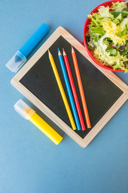 Foto grátis quadro-negro e papelaria perto de salada