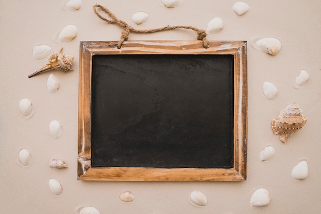 Foto grátis quadro-negro e seashells na praia