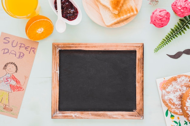 Foto grátis quadro-negro perto de comida e desenho para o pai