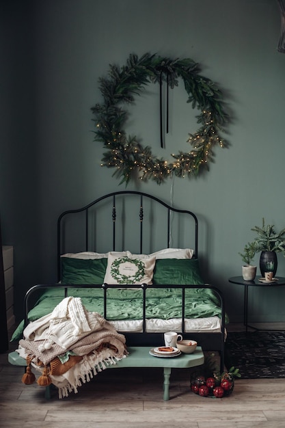 Quarto moderno com vista para as férias de Natal. Árvore de Natal decorada e iluminada, lareira com galho de pinheiro, velas e estrelas de papel artesanal na lareira.